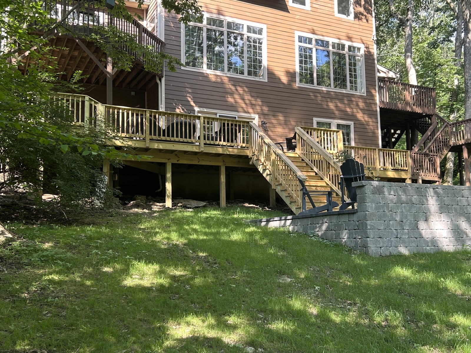 Large multi-level backyard deck with stairs and retaining wall