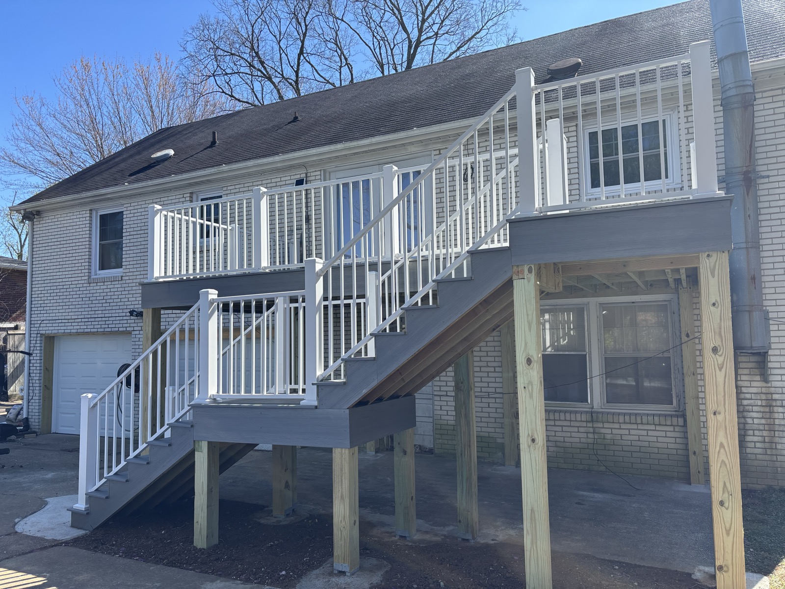 Elevated composite deck with slim white aluminum railing and matching stairs