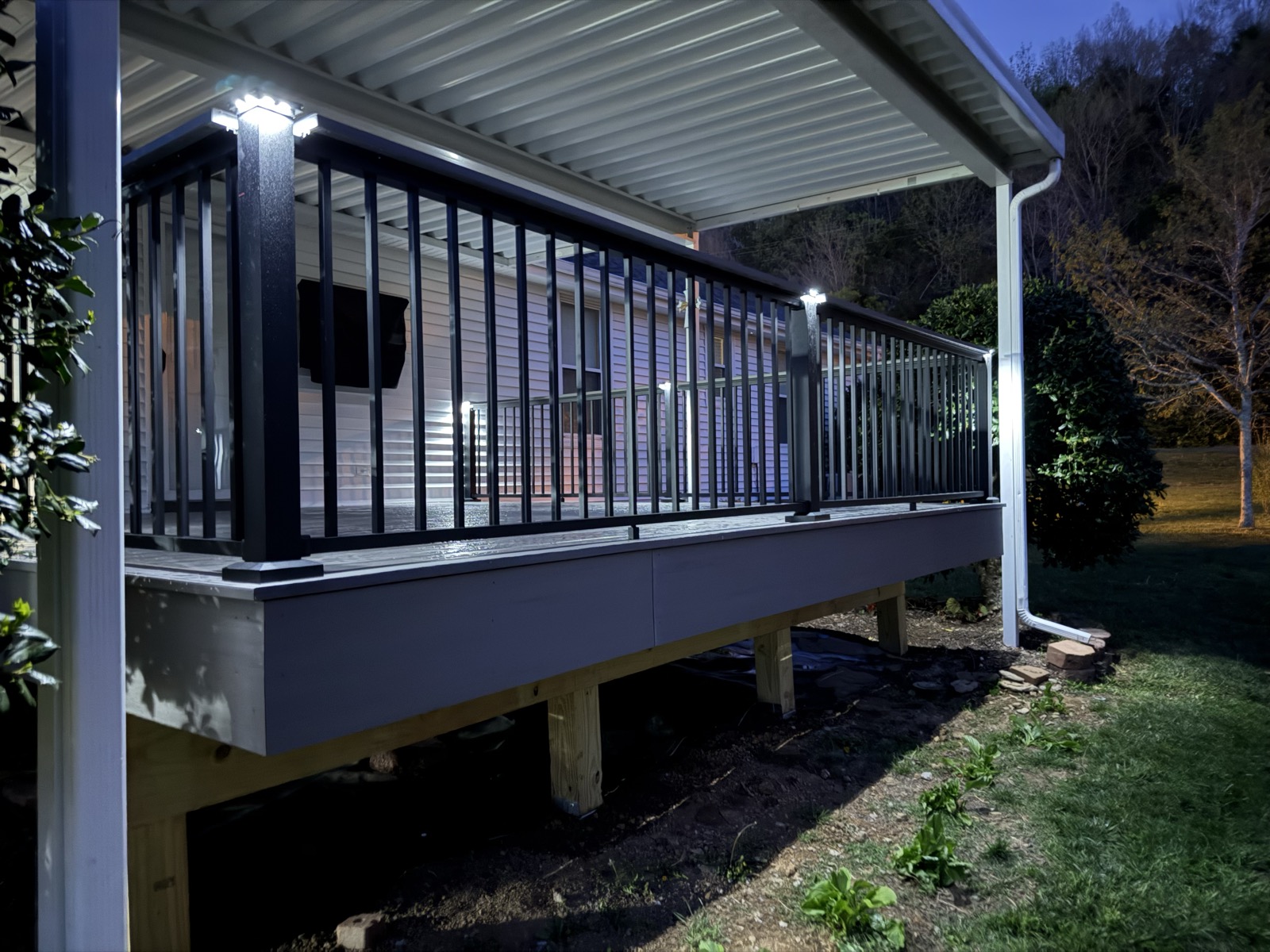 Composite deck at night glowing with post-cap and under-rail lighting